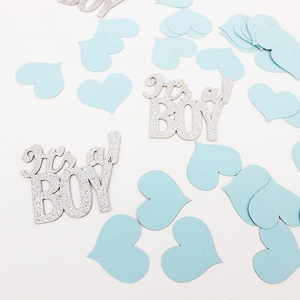 Close-up of baby shower confetti with blue hearts and silver glitter It's a BOY cutouts