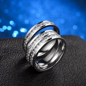 Detailed macro shot of two silver zircon eternity rings placed on a dark textured surface