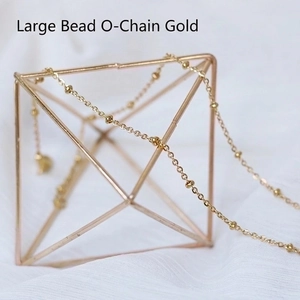 Detail of gold satellite chain with small solid beads on a metal display stand