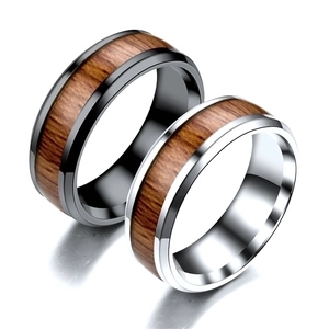 Macro detail of silver and black titanium rings with wood grain inlay and reflections