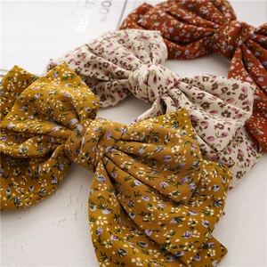 Three-layer knotted oversized floral bow hair clips in yellow, beige and red colors