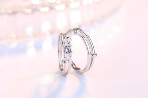 Macro shot of silver couple rings featuring a sparkling zircon stone and layered band