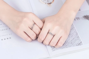 Minimalist silver dual-layer rings with a single round stone on an open fashion magazine
