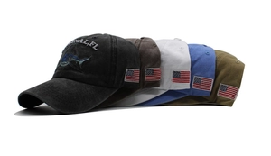 Detail showing various colors of washed cotton baseball caps with shark and flag embroidery