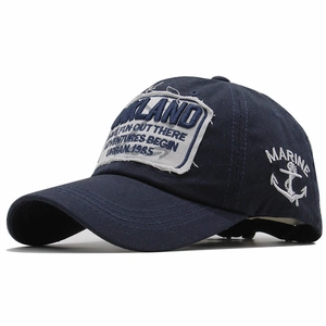 Detail of navy blue cotton baseball cap with anchor embroidery and vintage patch