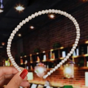 Detailed view of handmade bridal headband with woven cream pearls on a slim metal frame