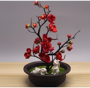 Detail of miniature garden bonsai featuring red plum blossoms and two cute resin rabbits