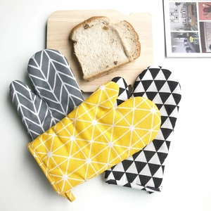 Detail of Nordic style oven mitts with geometric patterns in grey, yellow, and black colors