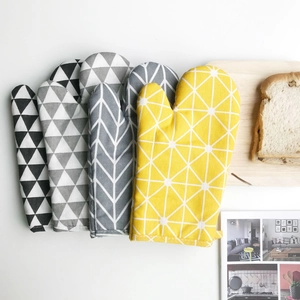 Close-up of Nordic style oven mitts featuring geometric patterns on a kitchen counter