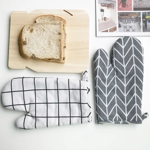 Detail of Nordic style cotton linen oven mitts set with wooden bread shaped board