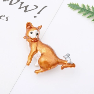 Detail of cute orange fox enamel brooch with silver mouse on a clean white background