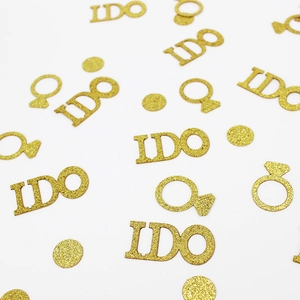 Close-up of champagne gold glitter I DO letters and ring shaped wedding confetti
