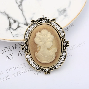 Macro shot of vintage bronze relief brooch with beige cameo and sparkling rhinestones