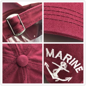 Detail view showing white MARINE embroidery and metal buckle on the burgundy cotton cap