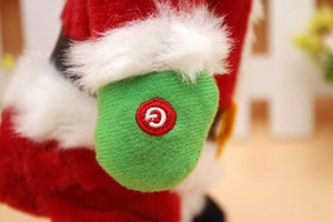 Close-up of the green power switch on a plush musical dancing Santa Claus toy