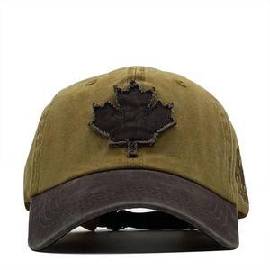 Detail of vintage washed baseball cap featuring a distressed maple leaf patch and side badge