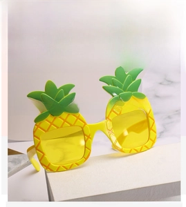 Detailaufnahme der lustigen Party-Sonnenbrille in Ananasform mit gelben Gläsern und Blättern