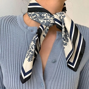 Detail of paisley pattern and striped borders on a cream-white cotton linen neck scarf