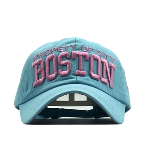 Detailed 3D pink embroidery on teal cotton baseball cap showing fine fabric texture