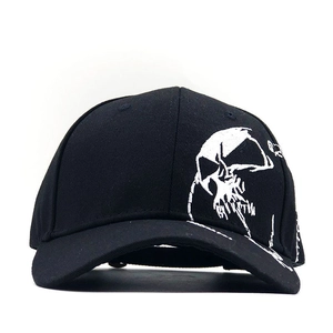 Close-up of a black baseball cap featuring a white skull embroidery on premium cotton twill