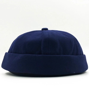 Detailed close-up of dark blue cotton docker hat with classic rolled edge and top button