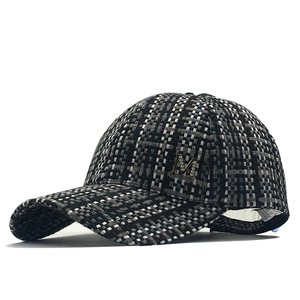 Detail of tweed checkered baseball cap with silver rhinestone M letter ornament