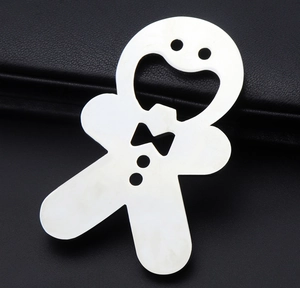 Detailed view of gingerbread man shaped silver metal bottle opener on dark background