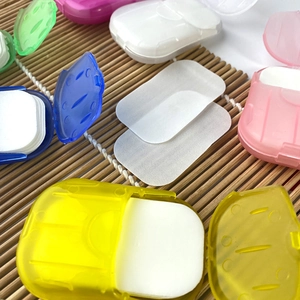 Colorful portable soap paper sheets in mini plastic boxes on a bamboo mat background