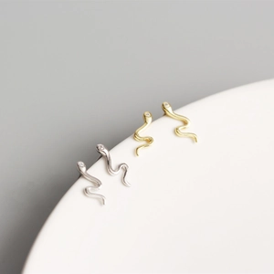 Close-up of gold and silver S925 sterling silver snake earrings with small diamonds