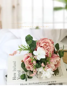 Close-up of artificial bridal bouquet with pink peonies and roses on vintage books