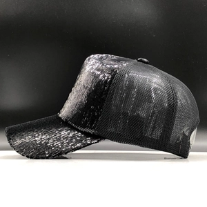 Close-up of black baseball cap with shimmering sequins and reinforced curved brim