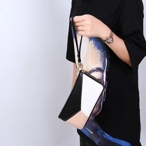 Detailed view of long wristlet wallet with geometric color-block patchwork and gold zipper