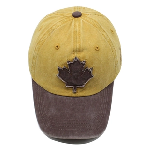 Detail of vintage washed baseball cap featuring a rustic maple leaf patch and worn edges