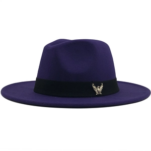 Detail of dark purple wool fedora hat with black ribbon and golden eagle emblem