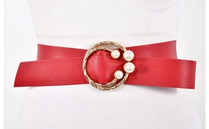 Gros plan d'une ceinture en similicuir rouge avec boucle ronde doree et quatre perles
