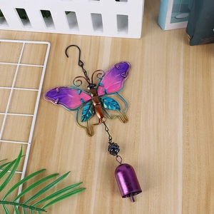 Close-up of butterfly wind chime with purple painted glass and vintage metal bell detail