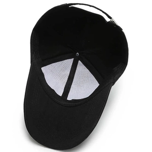 Internal structure of black cotton baseball cap showing seam tape and adjustable strap