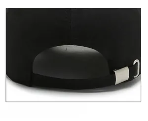 Close-up of the adjustable strap and silver metal buckle on the black baseball cap