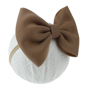 Détail d'un grand bandeau à nœud marron pour bébé avec une texture de tissu doux