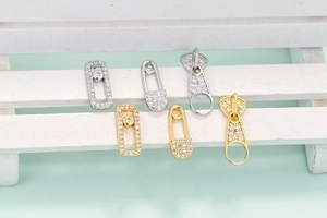 Orecchini a perno a forma di graffetta in oro e argento con zirconi su una mini scala bianca
