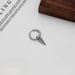 Close-up of stainless steel punk hoop earring with conical spike charm on white background