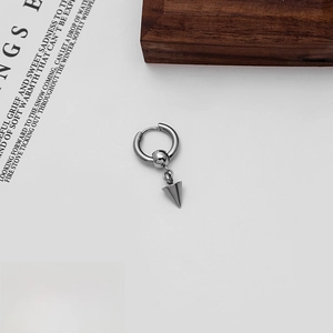 Macro view of silver punk hoop earring with conical spike pendant and steel texture