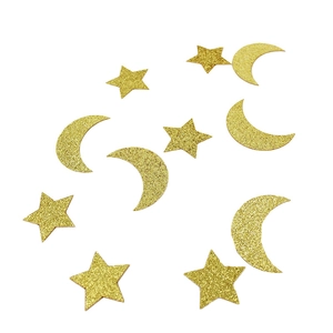 Golden star and moon confetti for birthday and wedding party decorations on white background