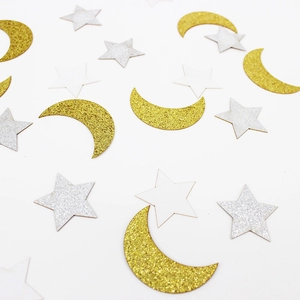 Close-up of gold and silver glitter star and moon confetti for party decoration