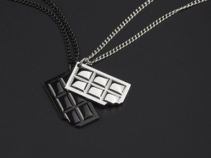 Macro detail of chocolate bar pendants in black and silver polished stainless steel