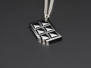Detail shot of a silver bite-marked chocolate pendant made of polished titanium steel