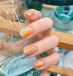 Detail of 3D gradient nail stickers with orange and blue shades and silver metallic lines