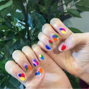 Detailed view of 3D colorful abstract dot nail stickers applied on natural fingernails