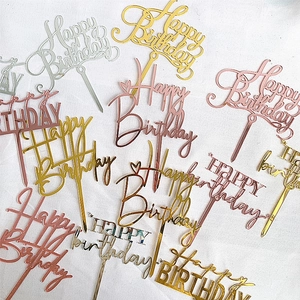 Acrylic Happy Birthday cake toppers in gold and silver colors on grey fabric background