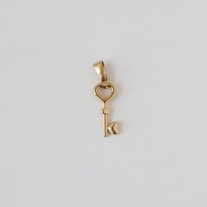 Detailed view of a polished 18k gold plated stainless steel heart-shaped key pendant